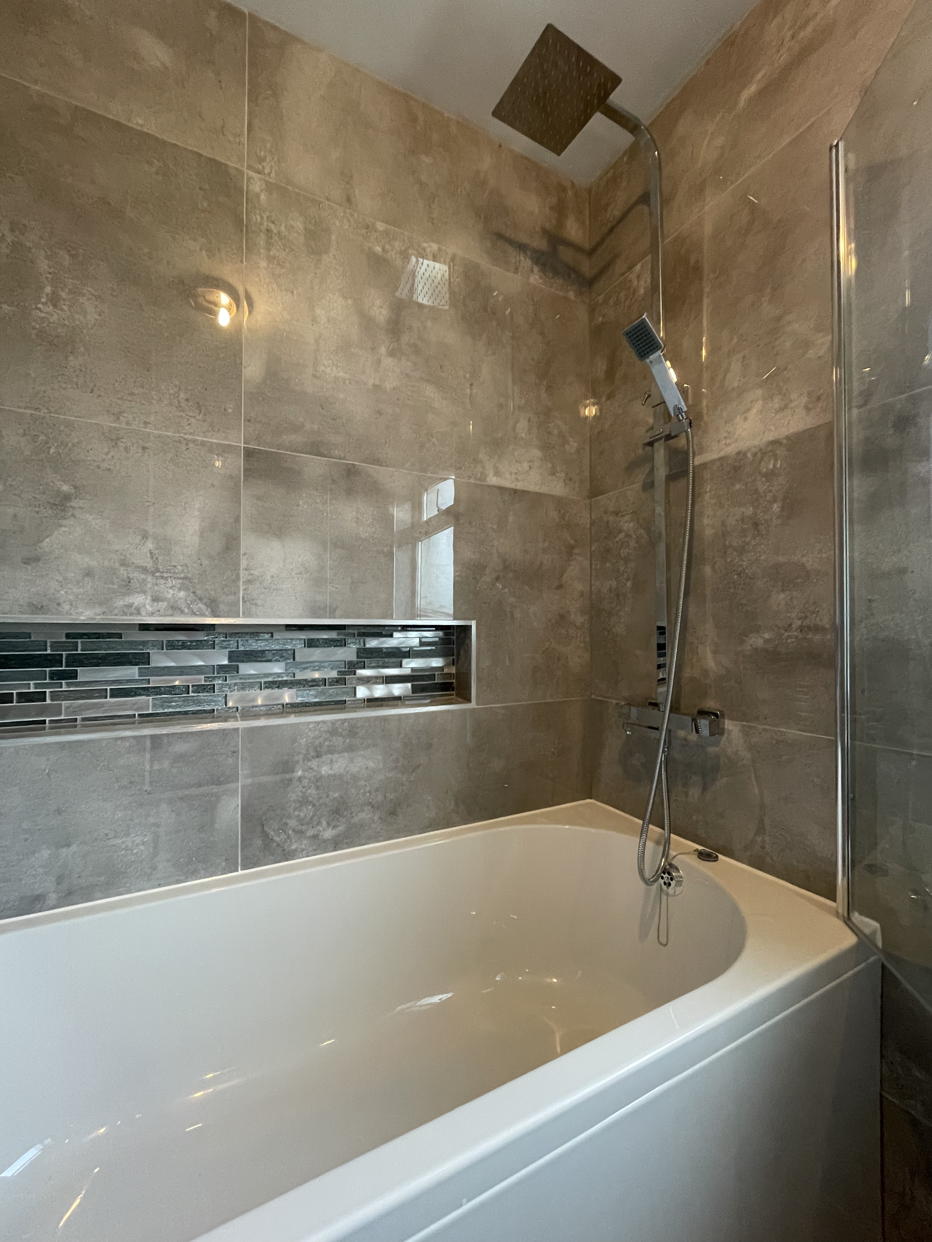 Bathtub with a stoned cut out in the back wall